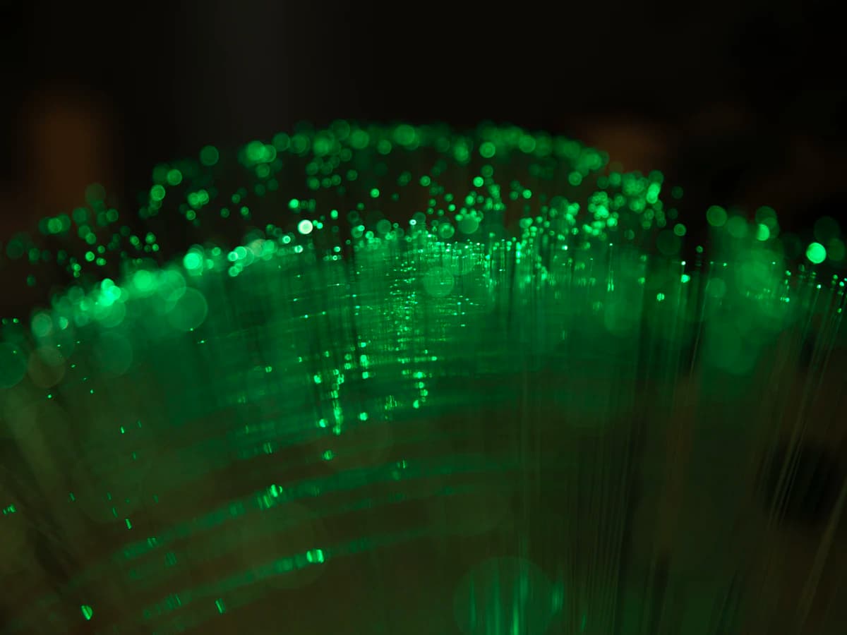 Green fiber-optic strands glowing in the dark
