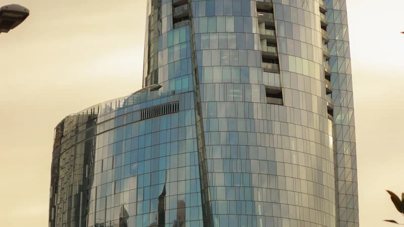 Glass skyscraper facade reflecting a sunset sky
